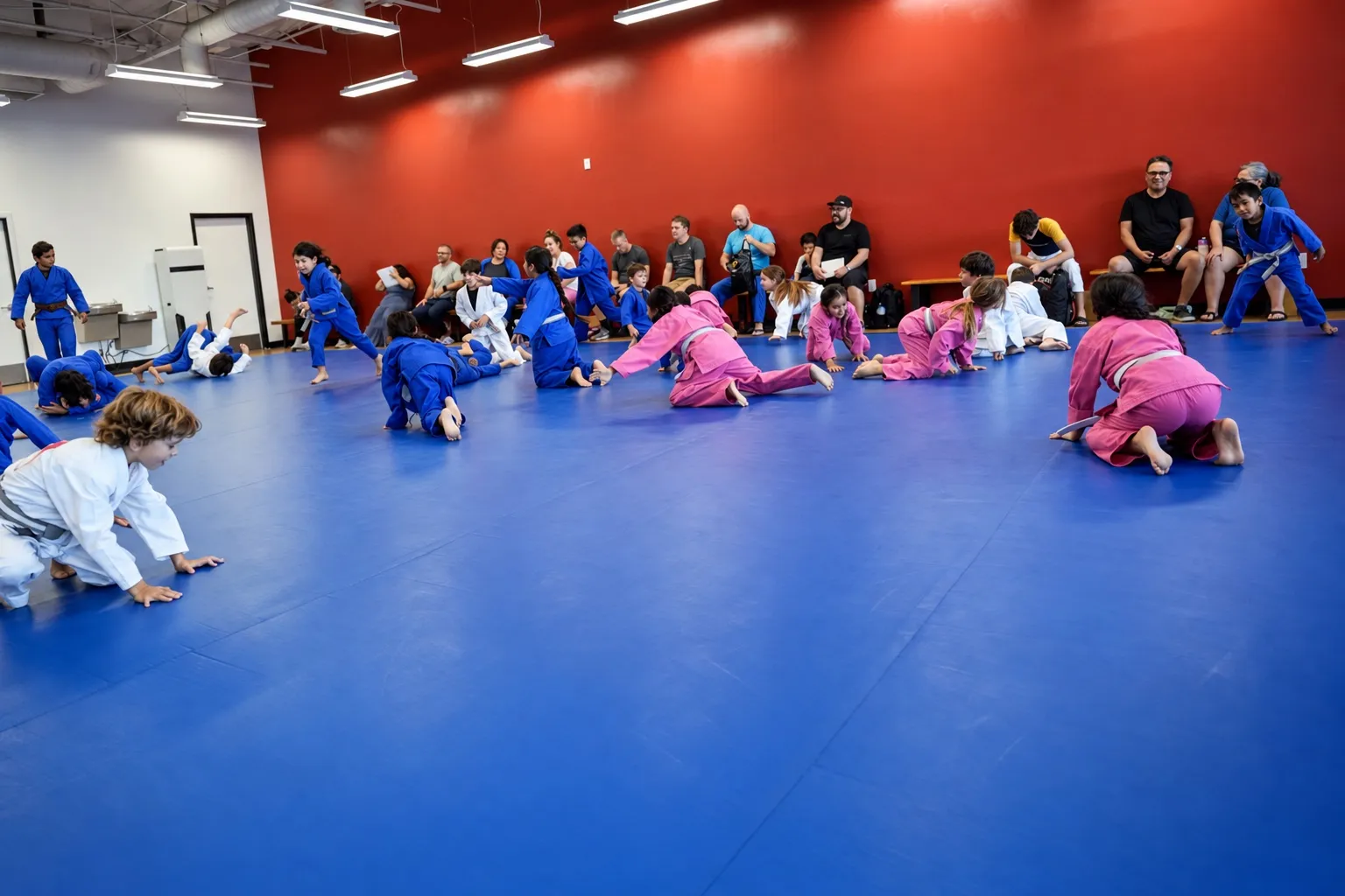 The Ahwatukee training room: blue mats, a red accent wall and parents watching from the benches
